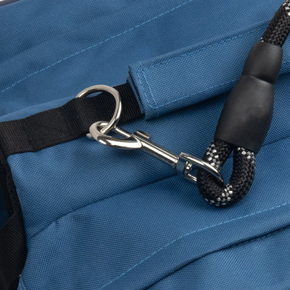 Pormenor da pega reforçada e da argola em D de uma mochila para cão, para maior controlo e compatibilidade com a trela.
