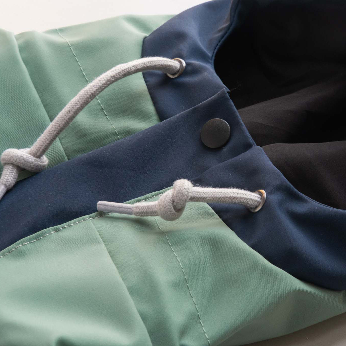 Dog raincoat hood with pull string, showcasing adjustable fit and protective waterproof design for outdoor adventures.