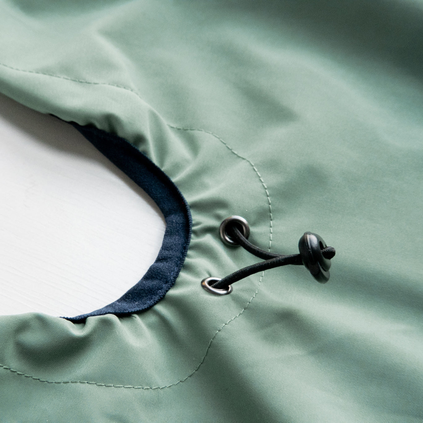 Dog raincoat with pull string, highlighting adjustable back length for a comfortable and custom fit during outdoor activities.