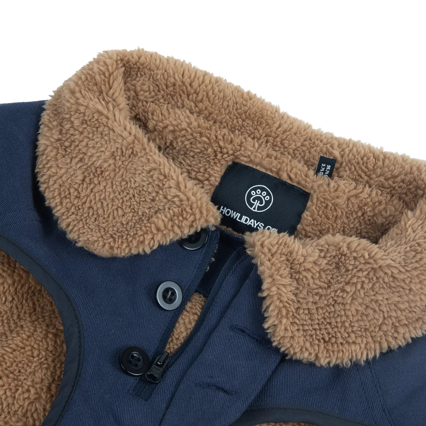 Pormenor de um casaco de inverno para cão com fecho de correr frontal e botões, concebido para vestir facilmente e garantir um ajuste seguro.